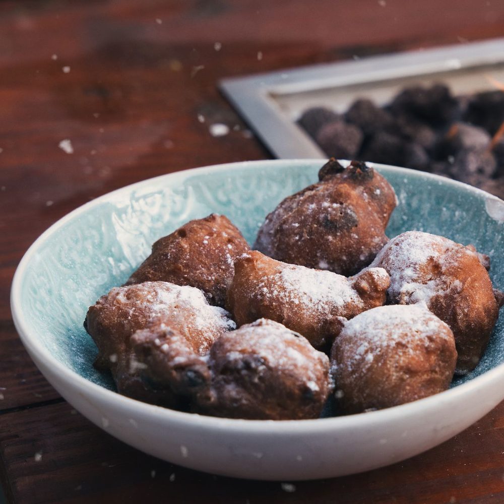 Een schaal oliebollen met poedersuiker