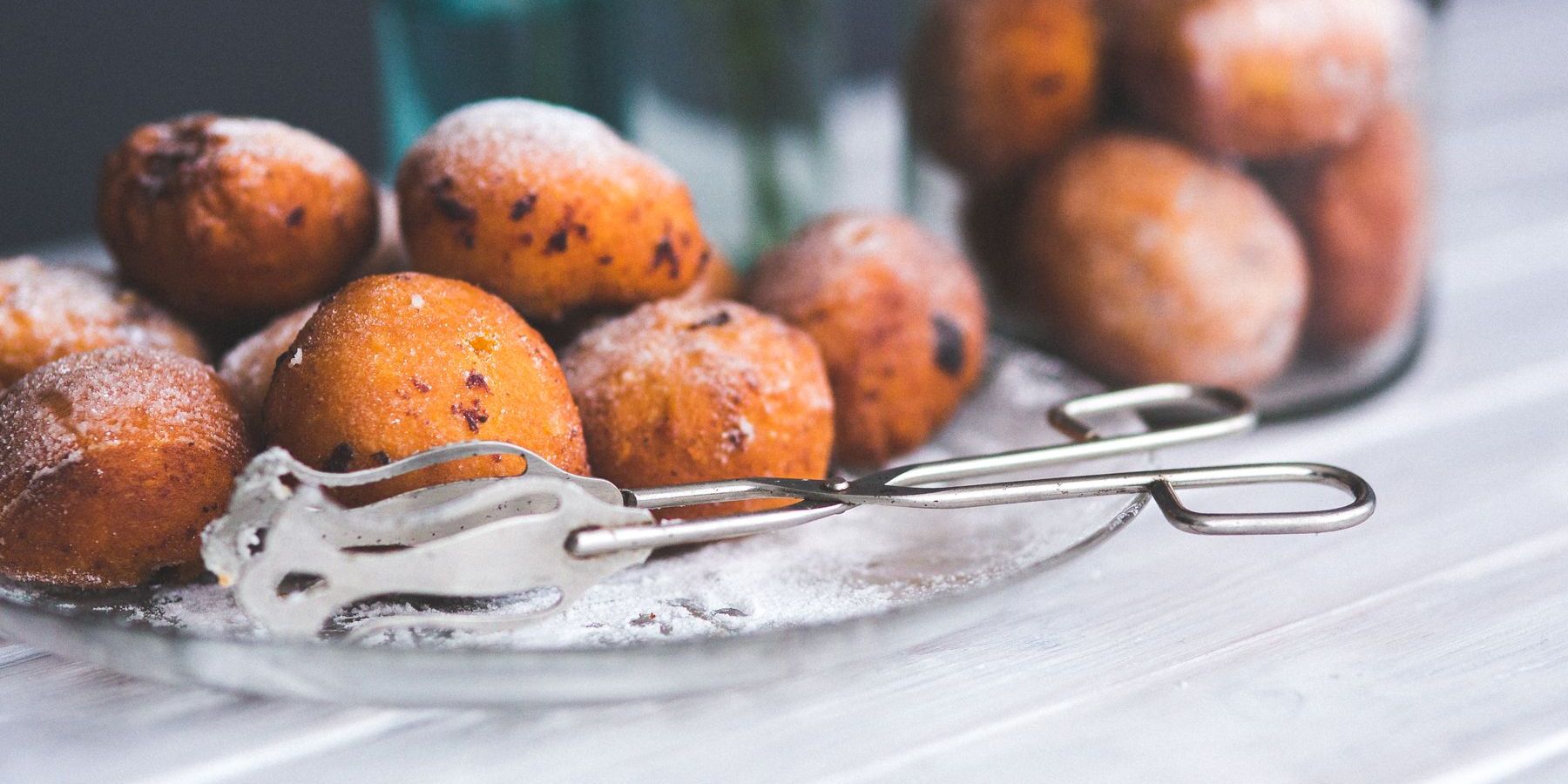 Verse oliebollen met poedersuiker op een glazen schaal